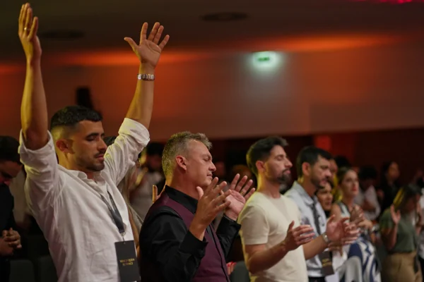 Participantes levantam a mão durante uma sessão